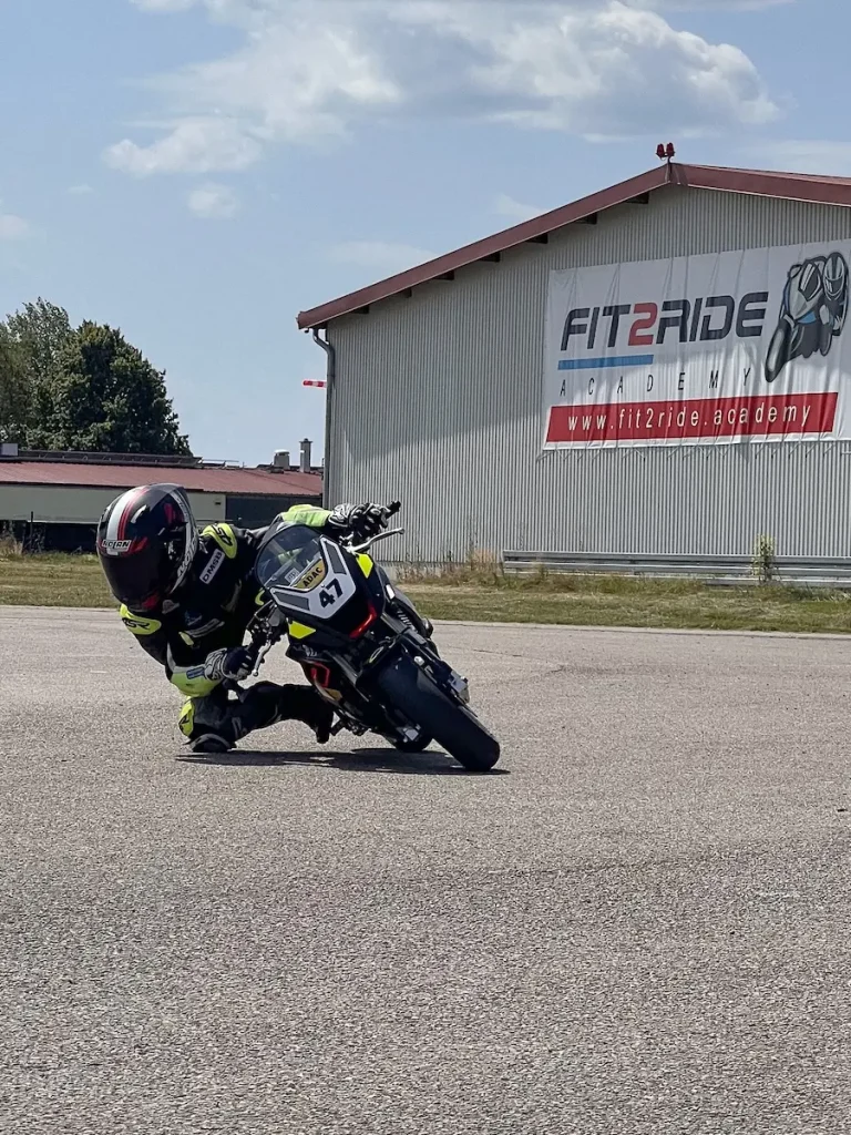 Junger Rennfahrer trainiert Kurvenlage und Blicktechnik auf einem Minibike im Förderprogramm.