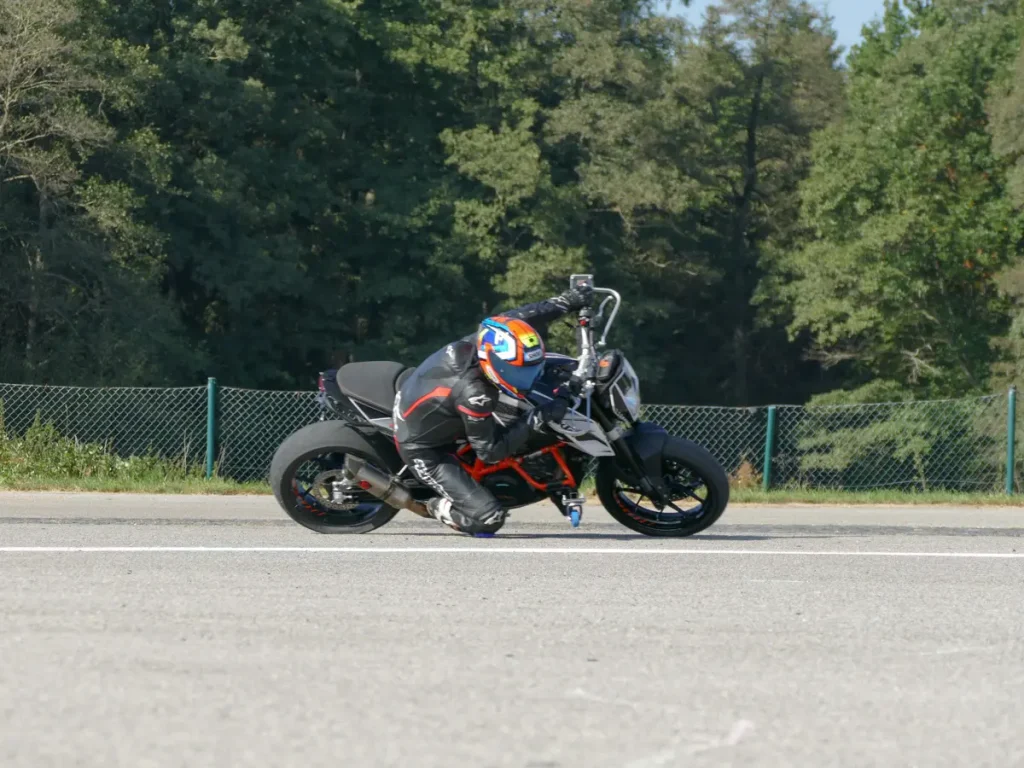 Fahrtechnik in Perfektion: Der Instruktor zeigt, wie man das Motorrad mit Auslegern kontrolliert und sicher durch die Kurve führt.